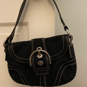 Black small Coach bag with buckle.